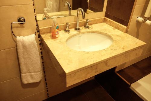 萨尔塔Departamento Salta的浴室柜台配有水槽和毛巾