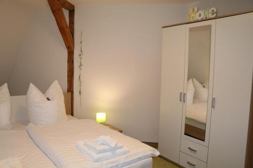 巴特埃尔斯特Fewo Friedrichsruh的卧室配有白色的床和镜子