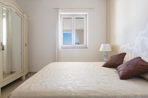 奥斯图尼Perla di Ostuni by BarbarHouse的一间卧室设有一张大床和窗户
