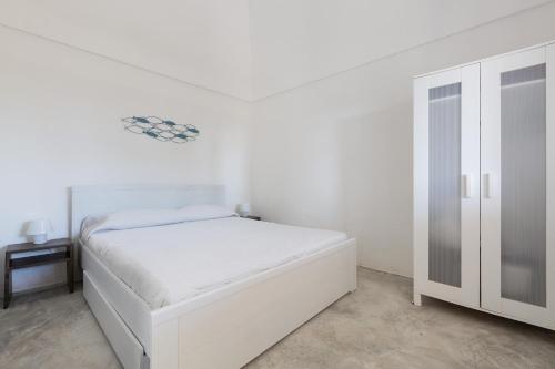 奥斯图尼La Murreddina by BarbarHouse的白色卧室配有白色的床和衣柜
