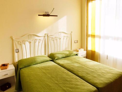 拉皮内达SHG Maldivas III的一间卧室配有一张带绿色床单的床和一扇窗户。