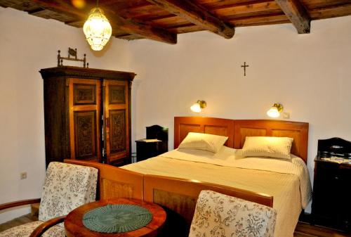 霍尔洛克Nefelejcs Vendégház Hollókő的卧室配有一张床,墙上有十字架