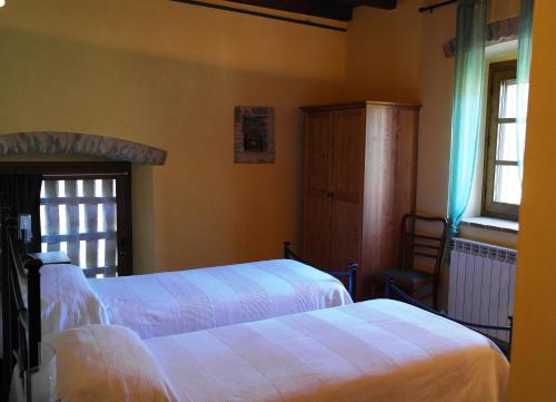 蓬特雷莫利艾乔司住宿加早餐旅馆的一间卧室设有两张床和窗户。