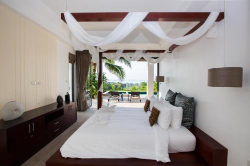功孟海滩班普奥别墅的卧室配有一张白色的大床和一张桌子