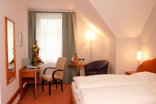 Markt Sankt Florian弗洛瑞安尔霍夫酒店的酒店客房配有一张床、一张书桌和一台笔记本电脑