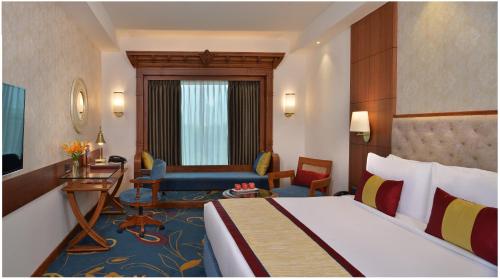 艾哈迈达巴德Fortune Landmark, Ahmedabad - Member ITC's Hotel Group的配有一张床和一张书桌的酒店客房