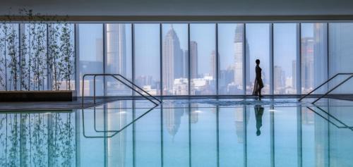 天津天津四季酒店的站在游泳池里看着城市的人