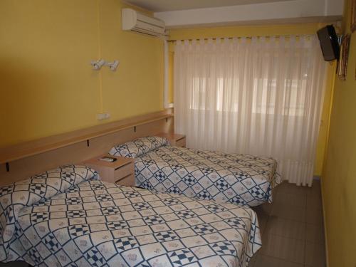 萨拉戈萨Hostal San Jorge的酒店客房设有两张床和窗户。