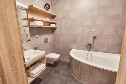 米库洛夫Apartmány Volarik的带浴缸、卫生间和盥洗盆的浴室