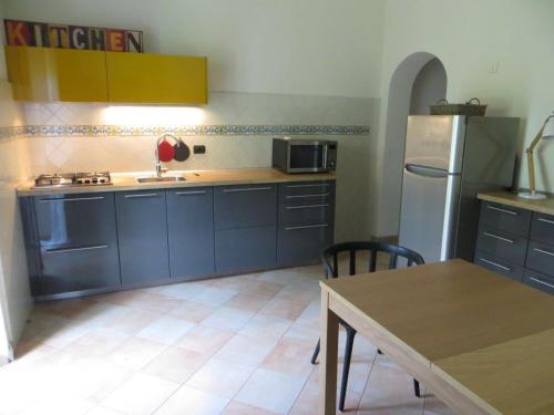 比萨卡萨加布里埃拉公寓的厨房配有蓝色橱柜、桌子和冰箱。