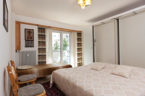 Sankt Moritz-BadChesa Derby 3的一间卧室配有一张床、一张书桌和一个窗户。