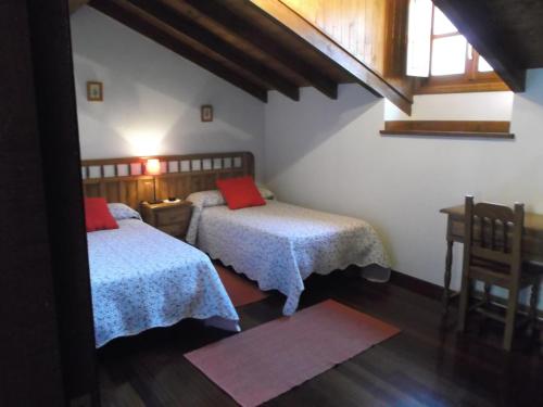PejandaPosada Casa Molleda的一间卧室设有两张床、一张桌子和一个窗口