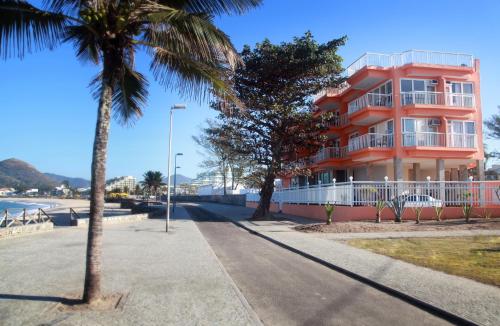 里约热内卢KS海滩酒店 的海滩上的一座建筑,前面有棕榈树