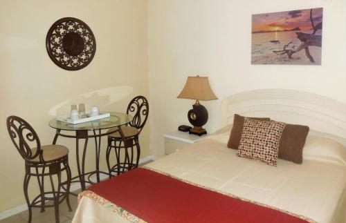 自由港市邓迪湾别墅酒店的一间卧室配有一张床和一张桌子及椅子