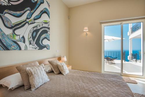 丰沙尔Balancal Apartments and Villas Palheiro Village的一间卧室设有一张床,享有海景