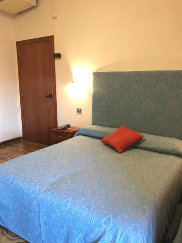 锡拉库扎斯卡拉格利卡酒店的一间卧室配有一张蓝色的床和红色枕头