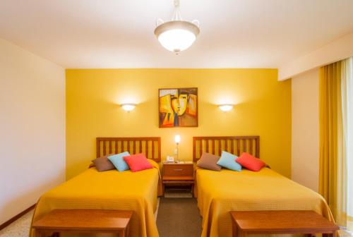Fortín de las FloresHotel Posada Loma的黄色墙壁客房的两张床