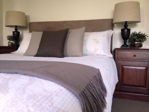 布里斯班Jacaranda House Garden Suite的一间卧室配有一张大床和两盏灯