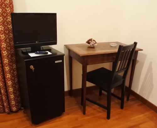 戈里齐亚Gorizia Inn的一张小桌子、一台电视和一把椅子