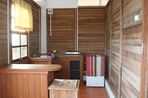 奥拉涅斯塔德Statia Lodge的厨房设有木墙、柜台和冰箱。