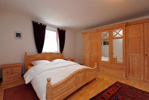 Bliesmengen-Bolchen佩兰酒店的一间卧室设有一张大型木床和一个窗户。
