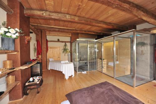 瓜热讷La Madernassa Resort - Casalora Dimora Storica di Charme的大房间设有玻璃淋浴间和桌子