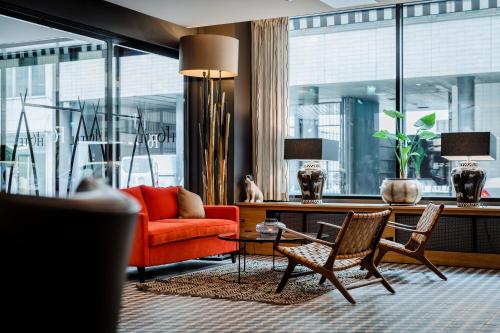 赫尔辛基F6酒店的客厅配有红色的沙发和椅子