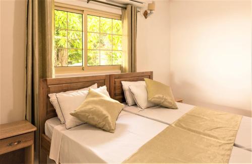 博瓦隆Korrine's Cottage HORIZON的一间卧室配有带两个枕头的床和窗户