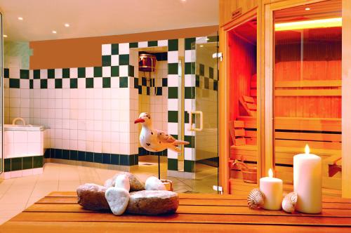 诺尔多夫Sonnenresort Hüttmann的浴室设有蜡烛和鸭子淋浴。