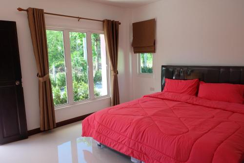 迈考海滩迈考海滩度假屋的一间卧室设有红色的床和窗户。