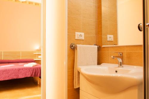 莱切Rooms Palazzo Paladini的一间带水槽和镜子的浴室