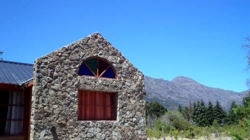 普埃洛湖El hostel secreto的一座带窗户的石头建筑,背景是群山