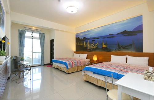 台东台东的家民宿的一间卧室设有两张床,墙上挂着一幅画