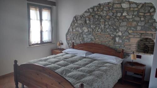 Villa VicentinaVilla Asiola的一间卧室设有一张带石墙的大床