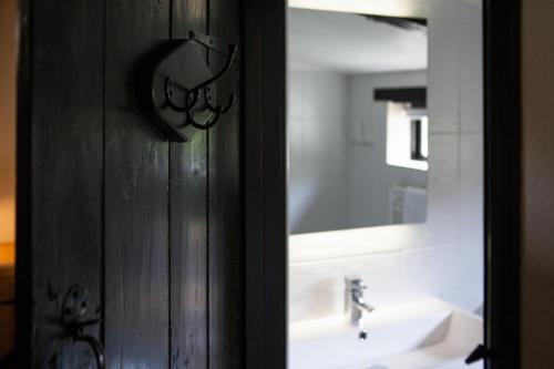Great Fransham诺福克格林班克斯酒店的浴室门设有水槽和镜子