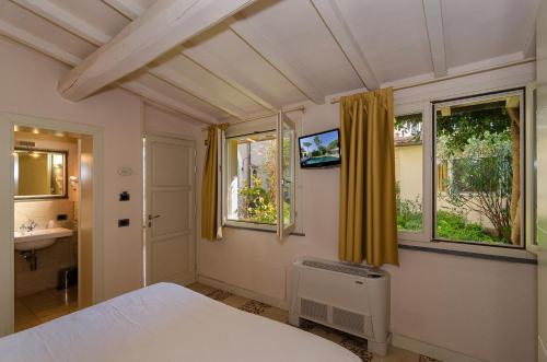 比萨诺文切托酒店的一间卧室配有床、水槽和窗户