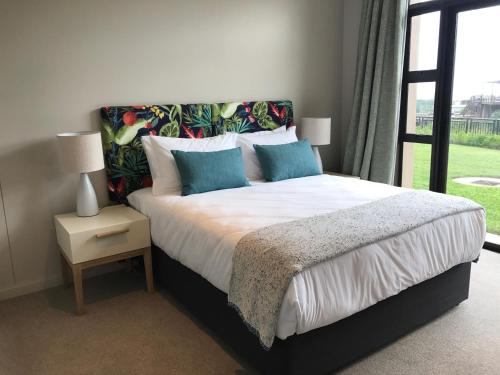 巴利托Zimbali Suite 107的一间卧室配有一张带蓝色枕头的床和一扇窗户。