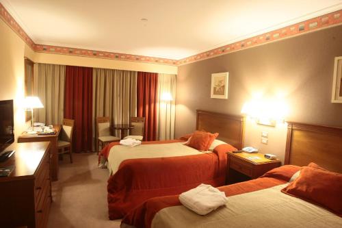 玛利亚镇Howard Johnson Villa María Hotel y Casino的酒店客房配有两张床和一张书桌