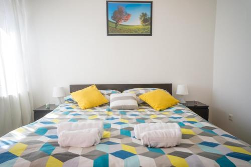 萨格勒布Blue Lake Apartment的一间卧室配有一张色彩缤纷的床和两个枕头