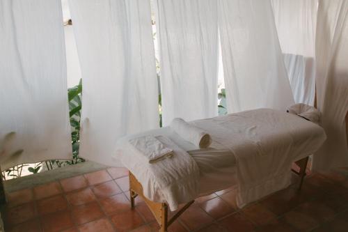 科潘玛雅遗址Casa Jaguar的一张小床,位于带白色窗帘的房间