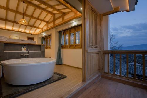 丽江丽江简舍客栈的带浴缸的浴室和阳台