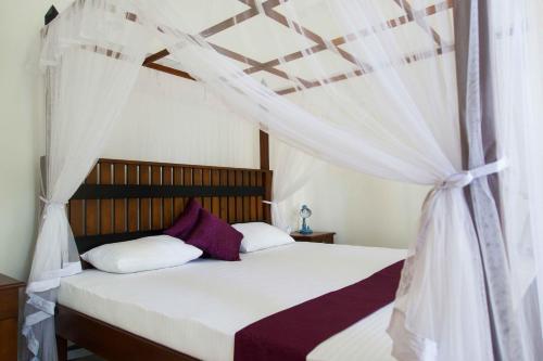 乌纳瓦图纳奥尔加别墅的一间卧室配有一张带天蓬的床