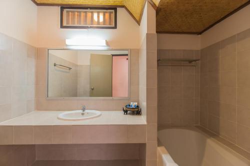 邦沙潘邦萨潘珊瑚酒店的一间带水槽、浴缸和镜子的浴室