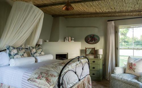 埃尔金Vredenhof Farm Cottage的卧室配有床、椅子和窗户。