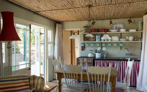 埃尔金Vredenhof Farm Cottage的一间带桌椅的厨房和一间用餐室