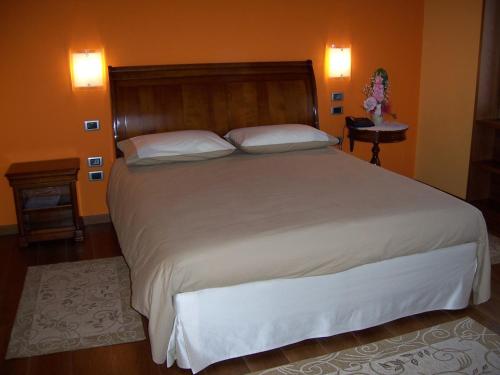 CastelcuccoLocanda da Gerry的卧室配有一张带白色床单和枕头的大床。