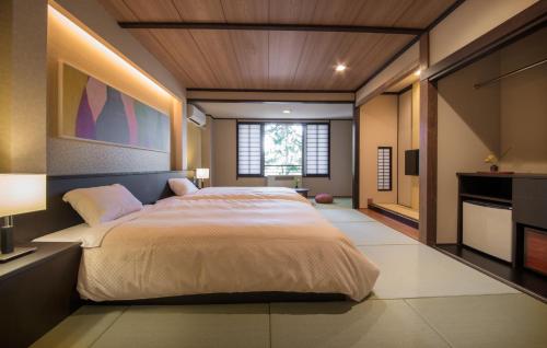 大町市织花日式旅馆的一间卧室设有一张大床和一个窗户。