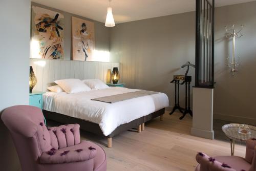 Écurie普拉美&克顿酒店的一间卧室配有一张大床和两把椅子