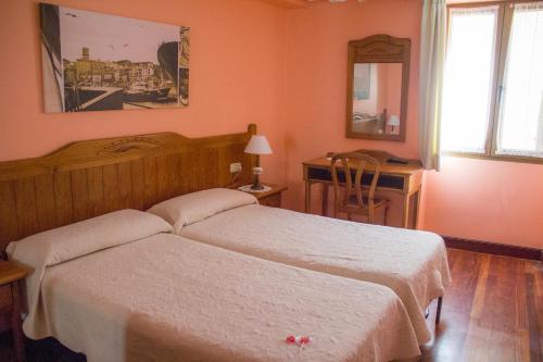 吉塔里亚赫塔里亚诺膳食公寓的一间卧室配有两张床和一张带镜子的书桌