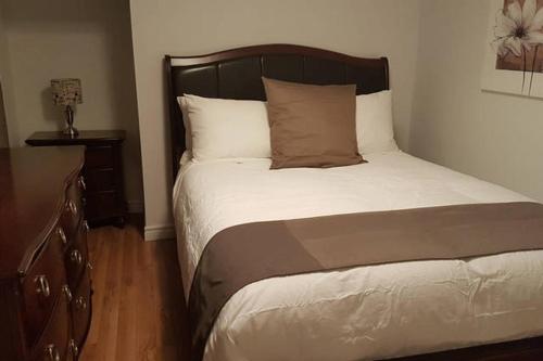 加蒂诺1-Bedroom Apartment Sweet #7 by Amazing Property Rentals的一间卧室配有一张带木制床头板的床和梳妆台。